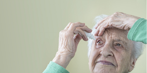 Senior putting eye drops in